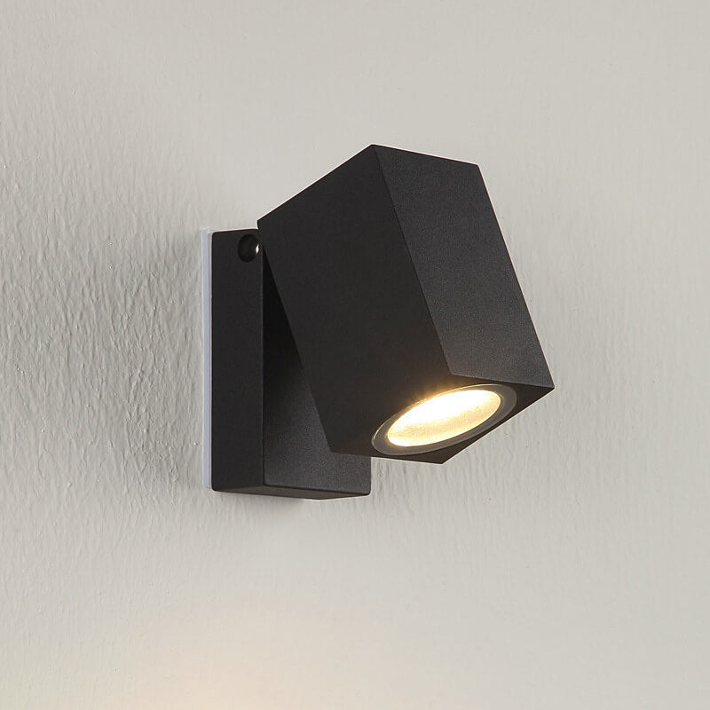 Black wall-mounted light fixture on a gray wall
