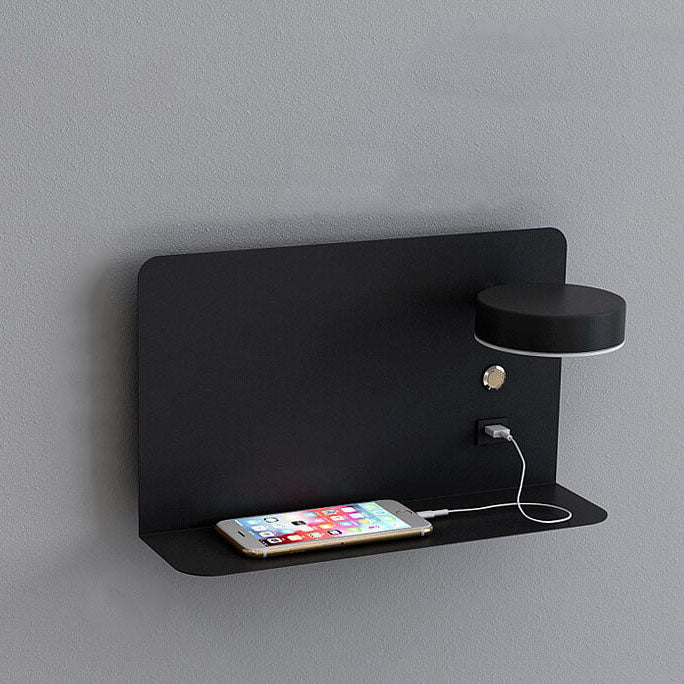 Black wall-mounted shelf with a lamp and smartphone on a gray background