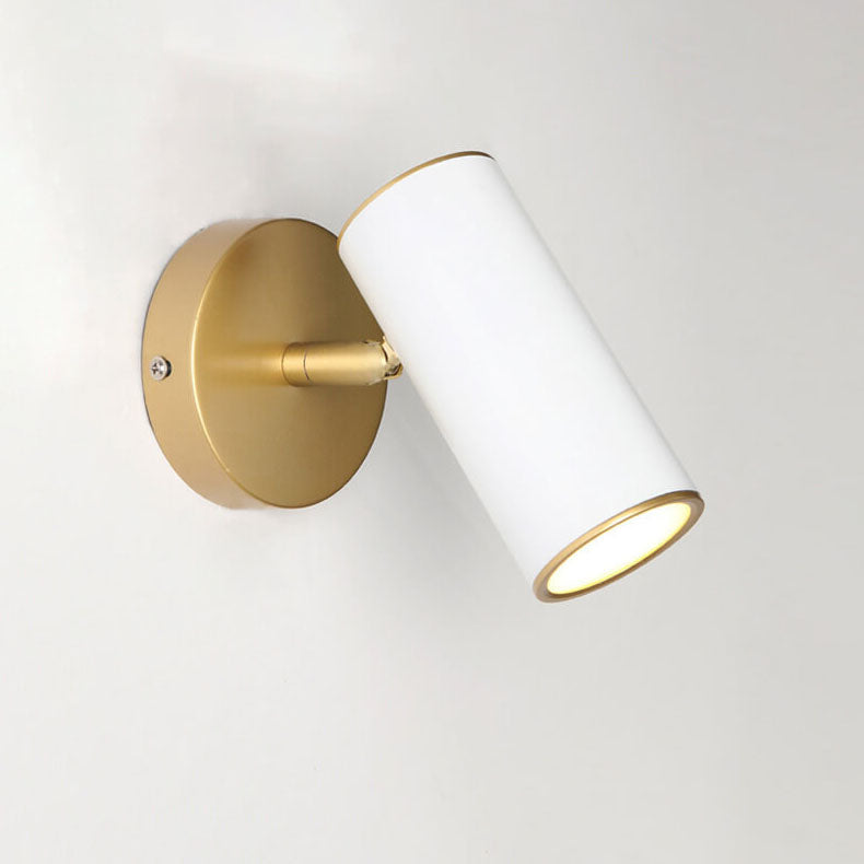 Wall-mounted light fixture with white cylindrical shade and gold base on a light gray background