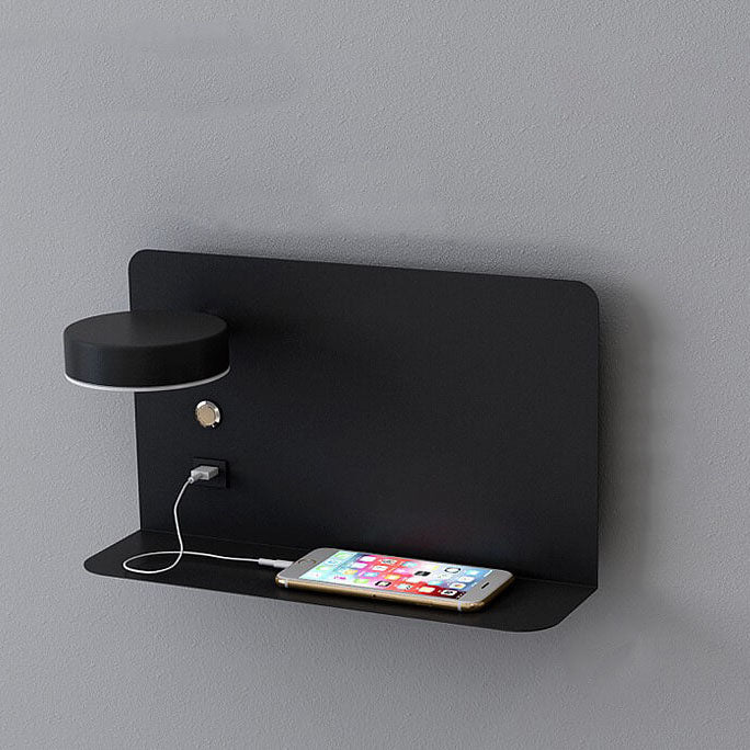 Black wall-mounted shelf with a smartphone and small lamp on a gray background