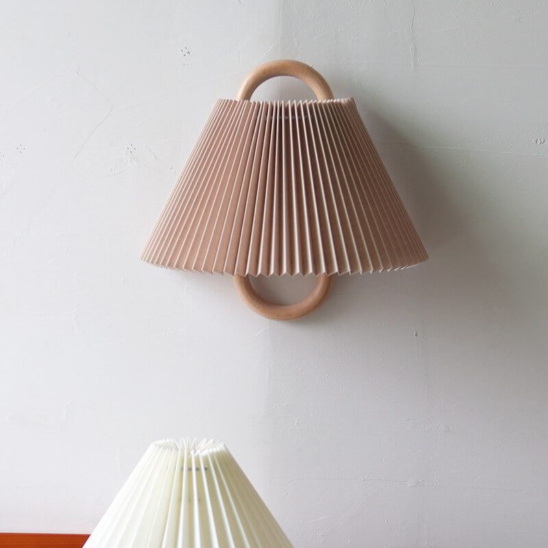Wall-mounted pleated lamp with wooden handle on a white wall