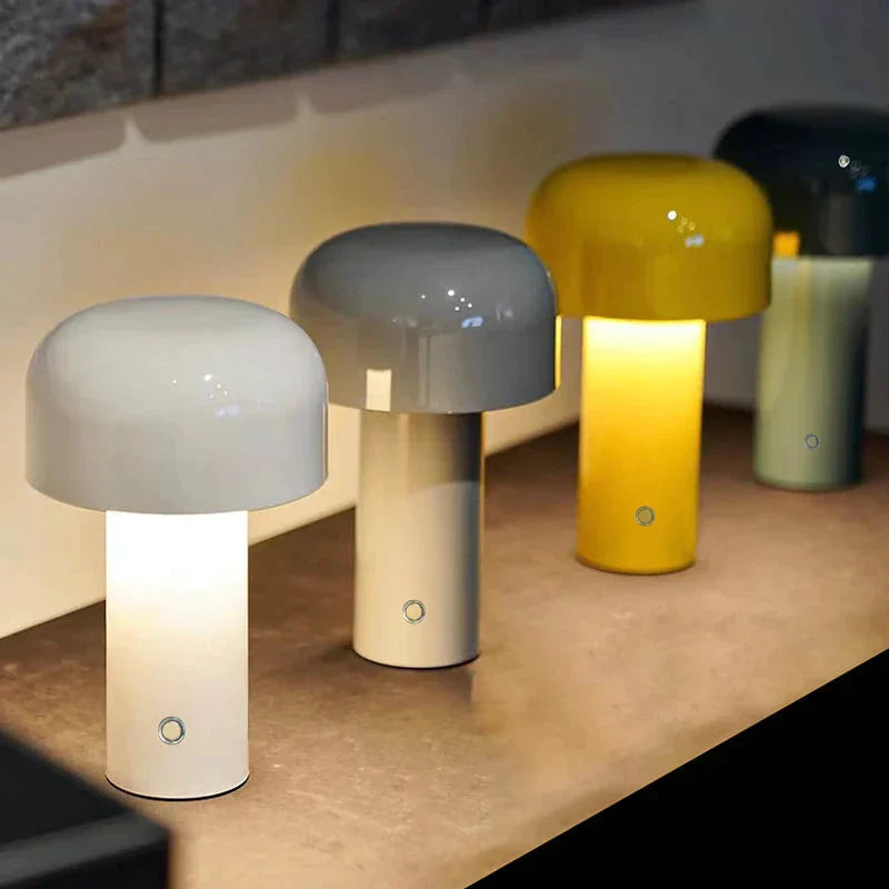 Three mushroom-shaped lamps in different colors on a surface.