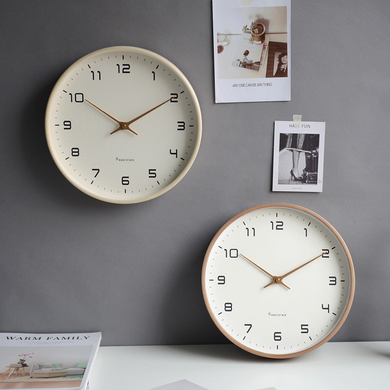 Two wall clocks on a gray wall with decorative photos.