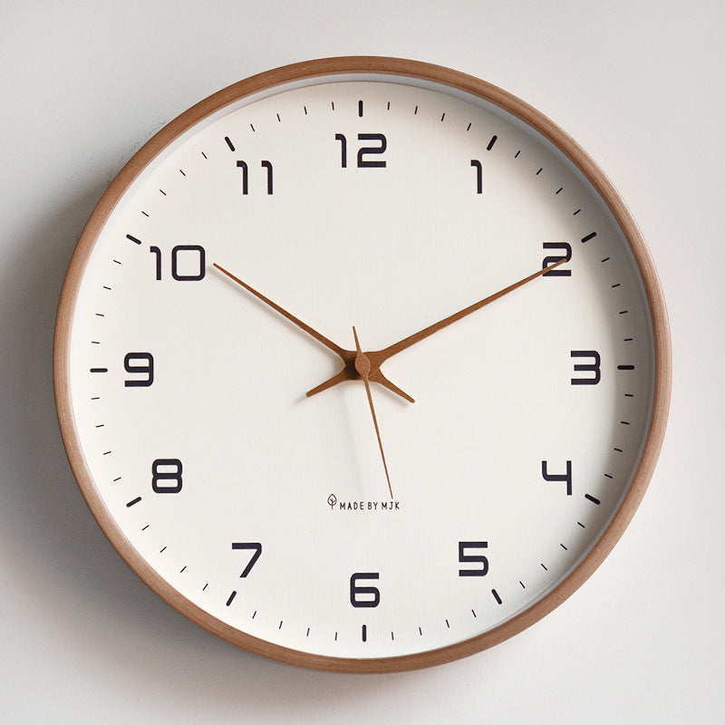 Round wall clock with wooden frame and white face on a light gray background