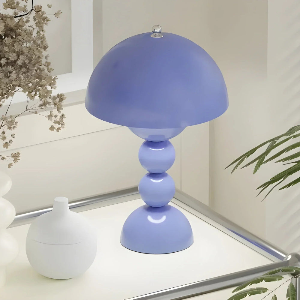 Purple table lamp on a surface with decorative elements in the background