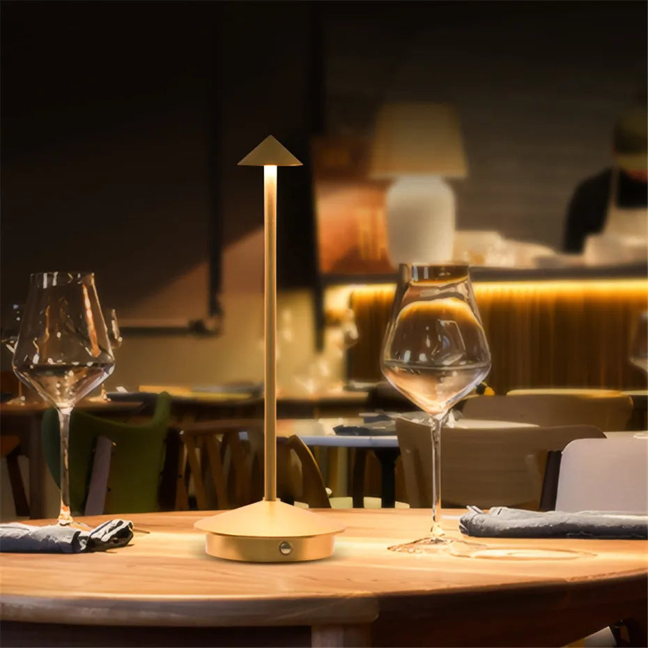 Modern table lamp on a wooden table with wine glasses in a restaurant setting