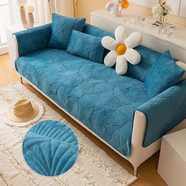 Blue textured sofa cover on a white sofa with decorative pillows in a living room setting.