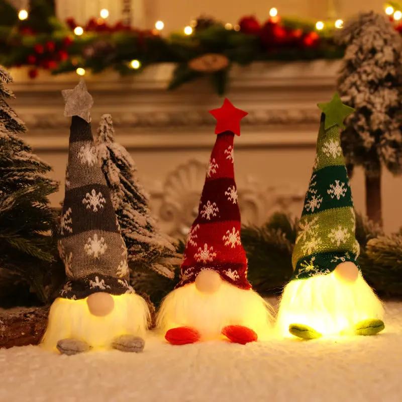 Three LED gnome figurines with colorful hats in a festive setting.