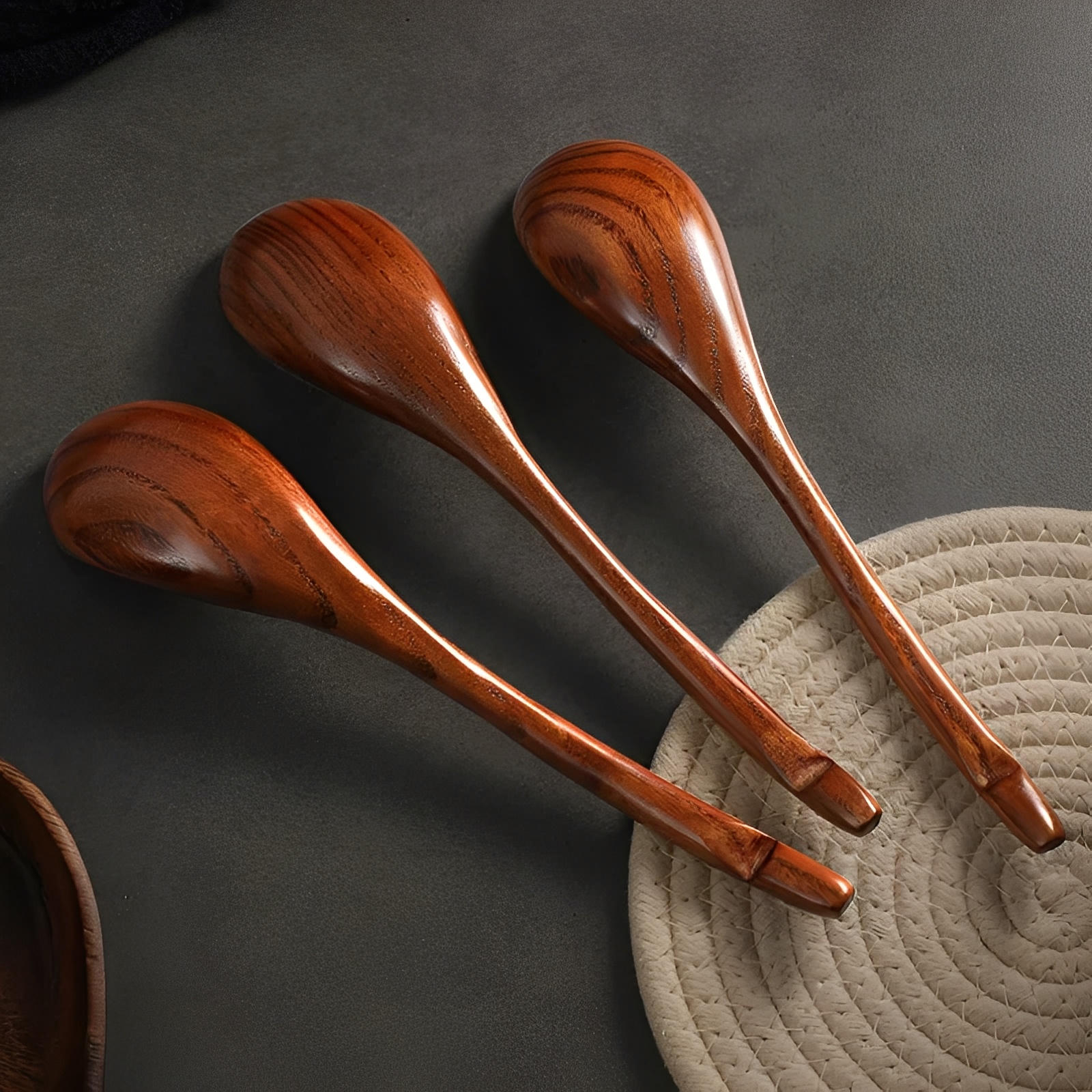 Three wooden spoons on a textured surface