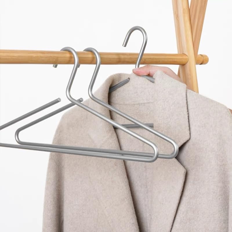 Metal hangers on a wooden rack with a beige coat.