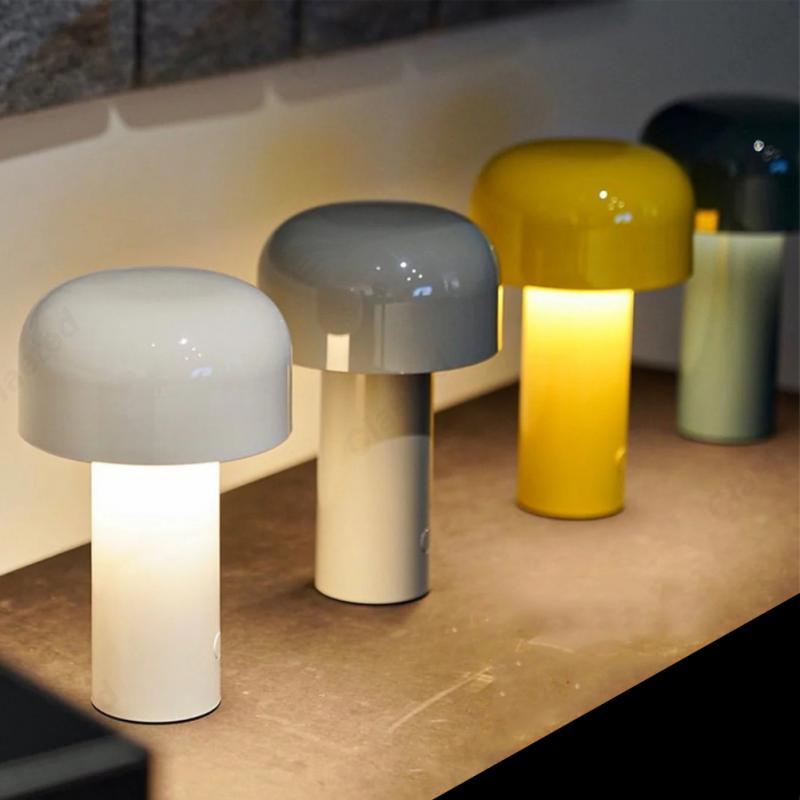 Three mushroom-shaped lamps in different colors on a surface.