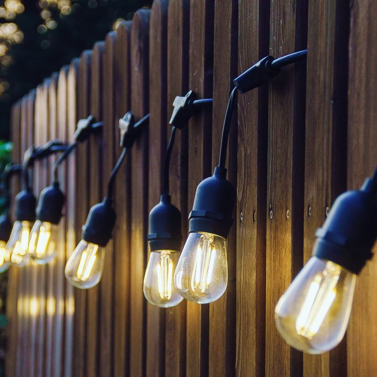 String of lights with vintage-style bulbs attached to a wooden fence