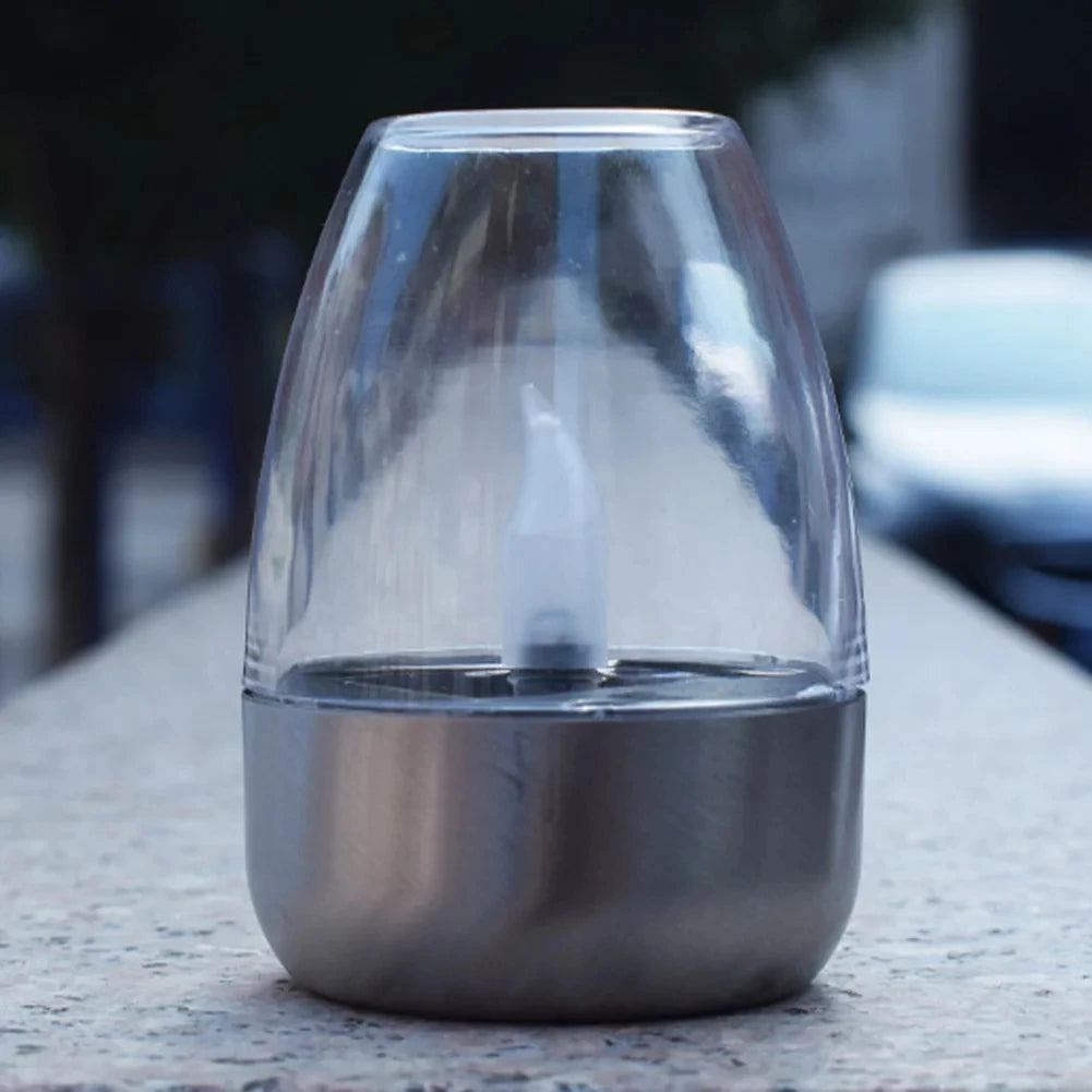Clear glass container with metal base on a textured surface