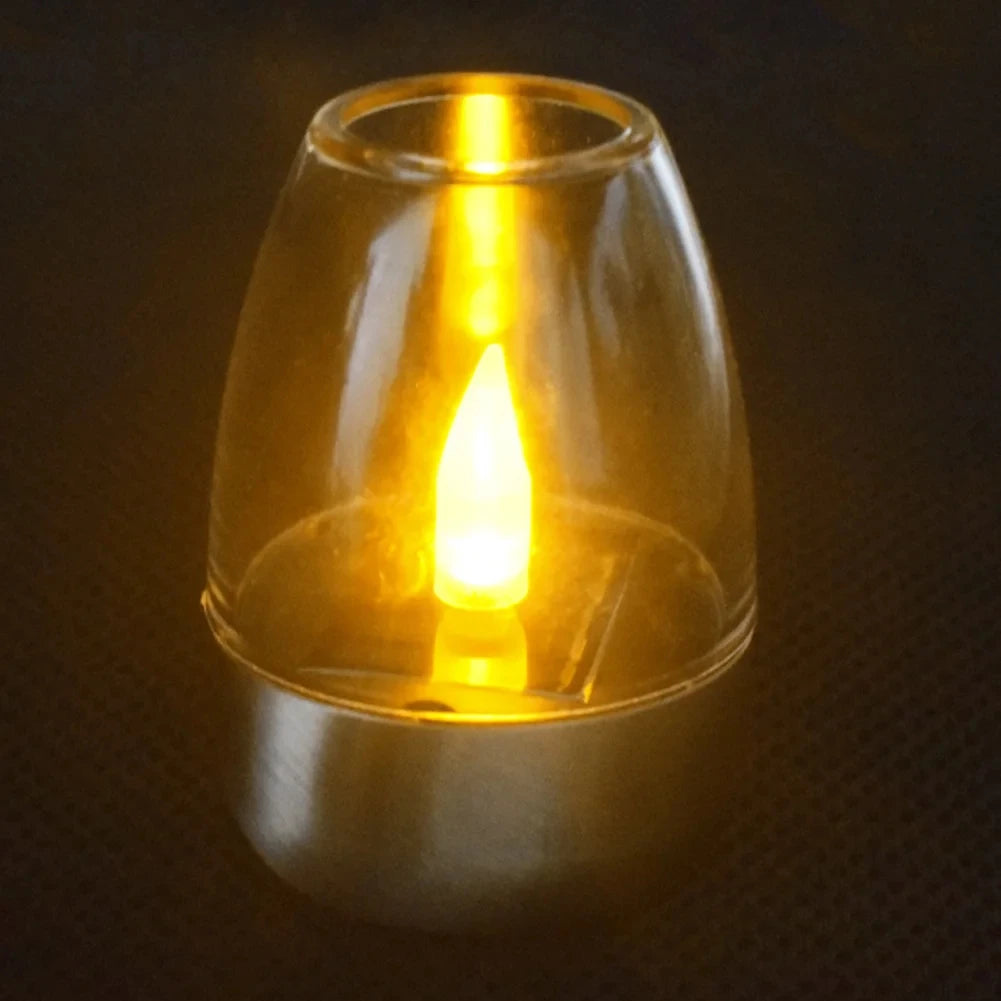 Glass candle holder with a lit candle inside on a dark background
