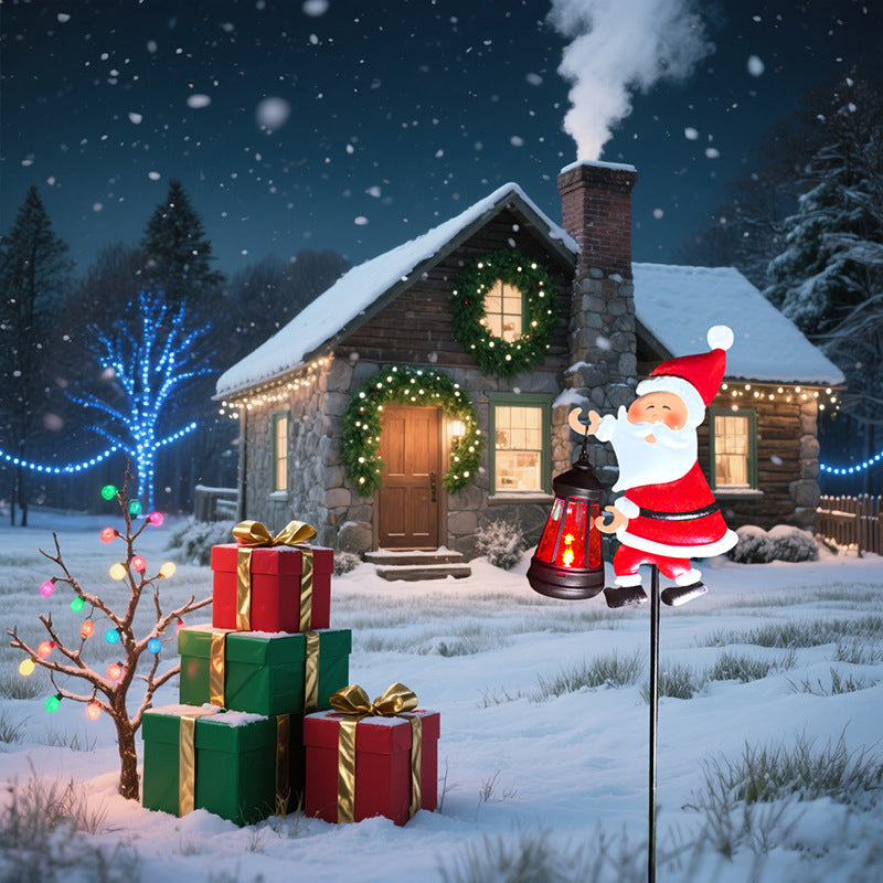Christmas scene with a house, Santa Claus figure, and gift boxes in a snowy landscape.
