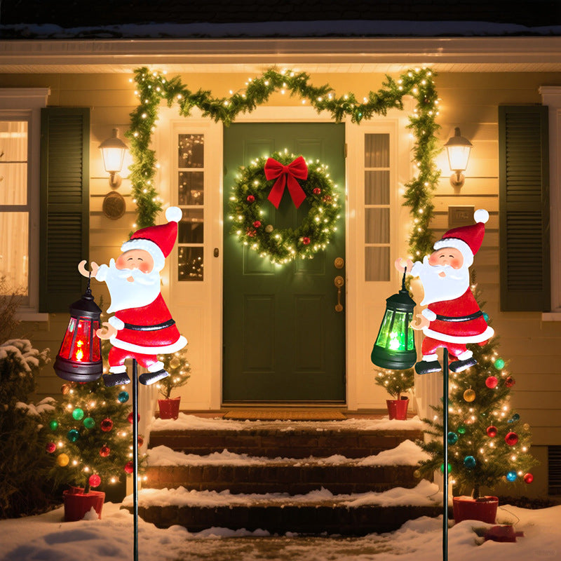 Decorative Christmas scene with Santa figures, wreath, and lights on a house exterior.