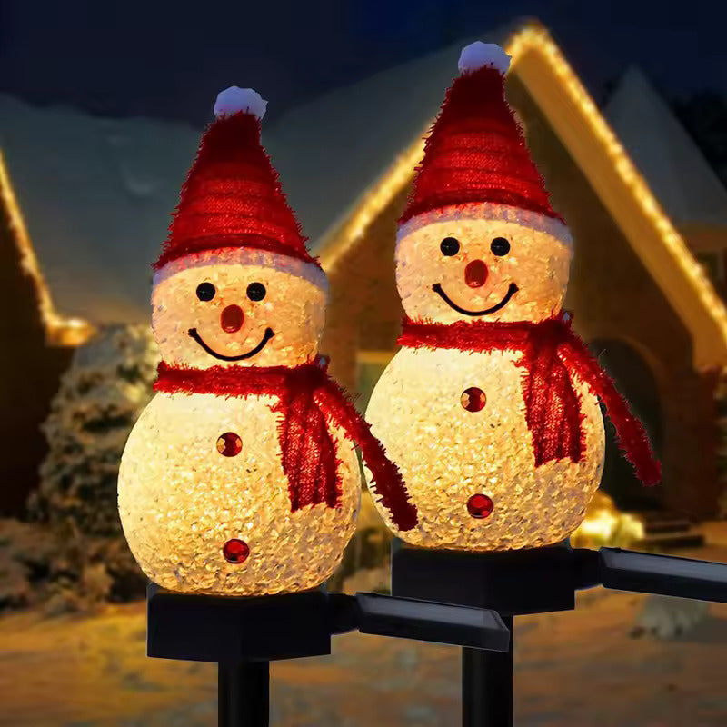 Two illuminated snowman lights with red hats and scarves on a dark background.
