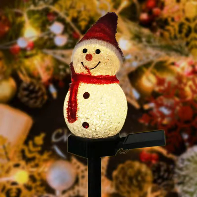 Decorative snowman light with a red scarf and hat on a blurred Christmas tree background.