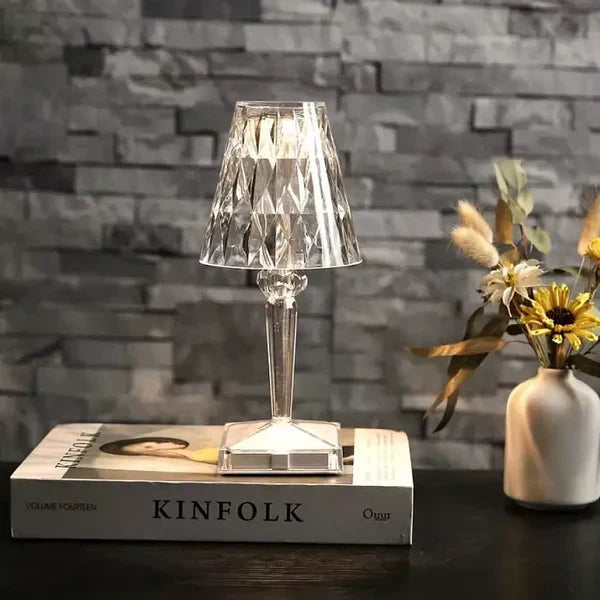 Crystal table lamp on a book with a stone wall background