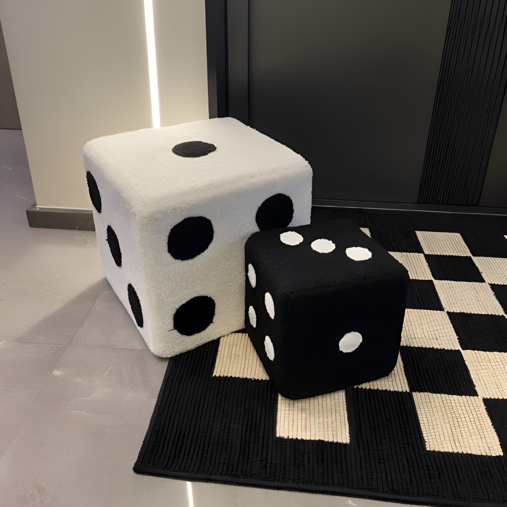 Two dice-shaped ottomans, one white with black dots and one black with white dots, on a checkered floor.
