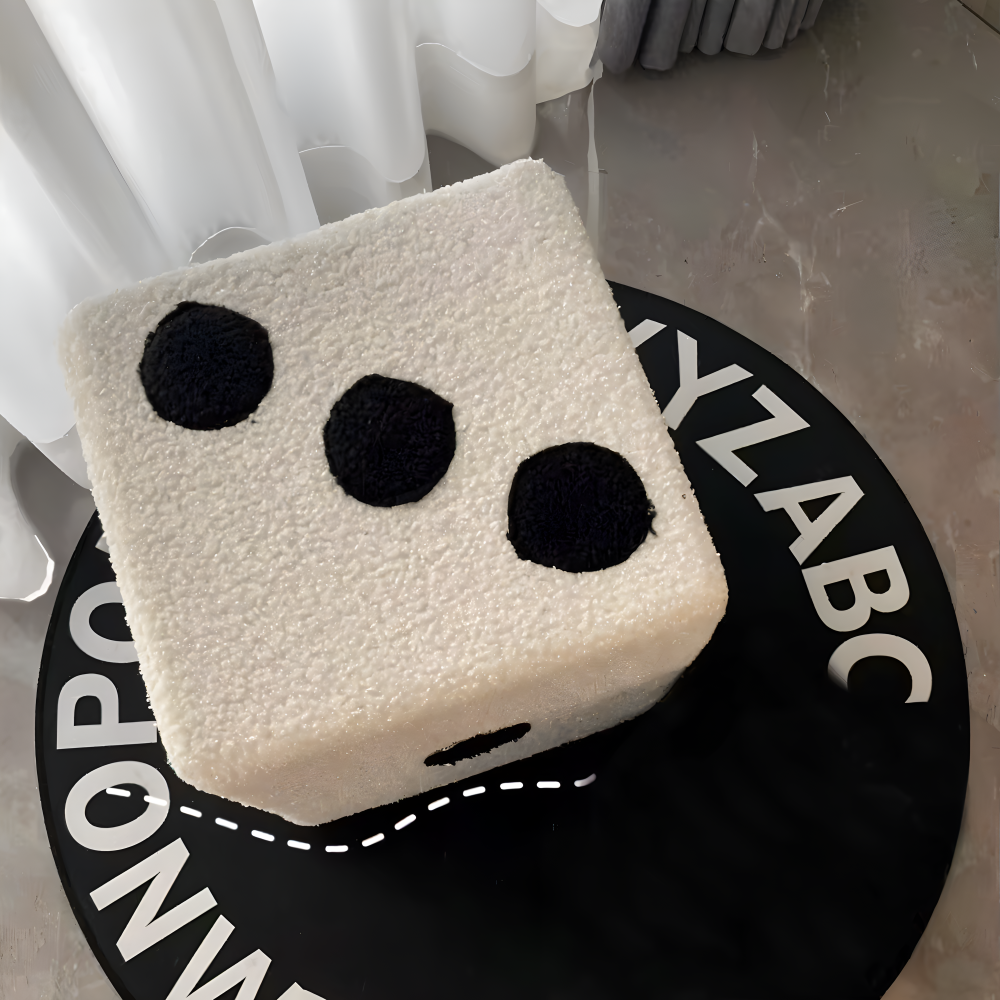Square cushion with black circle design on a circular mat with alphabet print