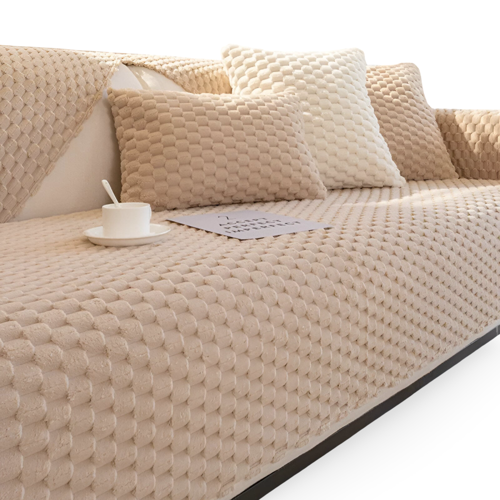 Beige textured sofa with cushions and a small table on a white background