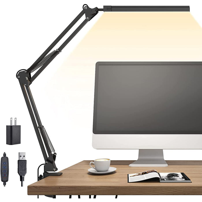 Desk lamp with adjustable arm on a desk next to a computer monitor.