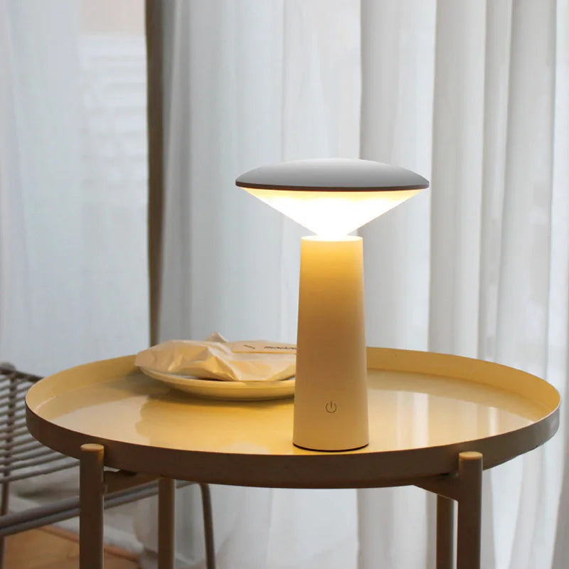Modern table lamp on a round wooden table with a neutral background