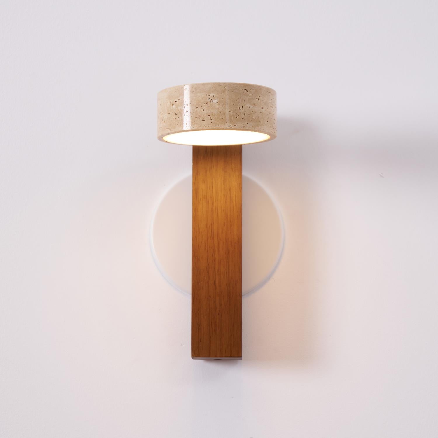 Wall-mounted light fixture with wooden base and textured beige shade on a white wall.