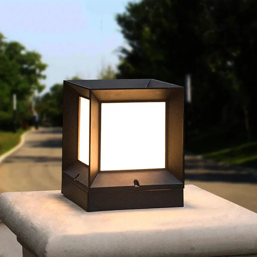 Square outdoor light fixture on a stone surface with trees in the background