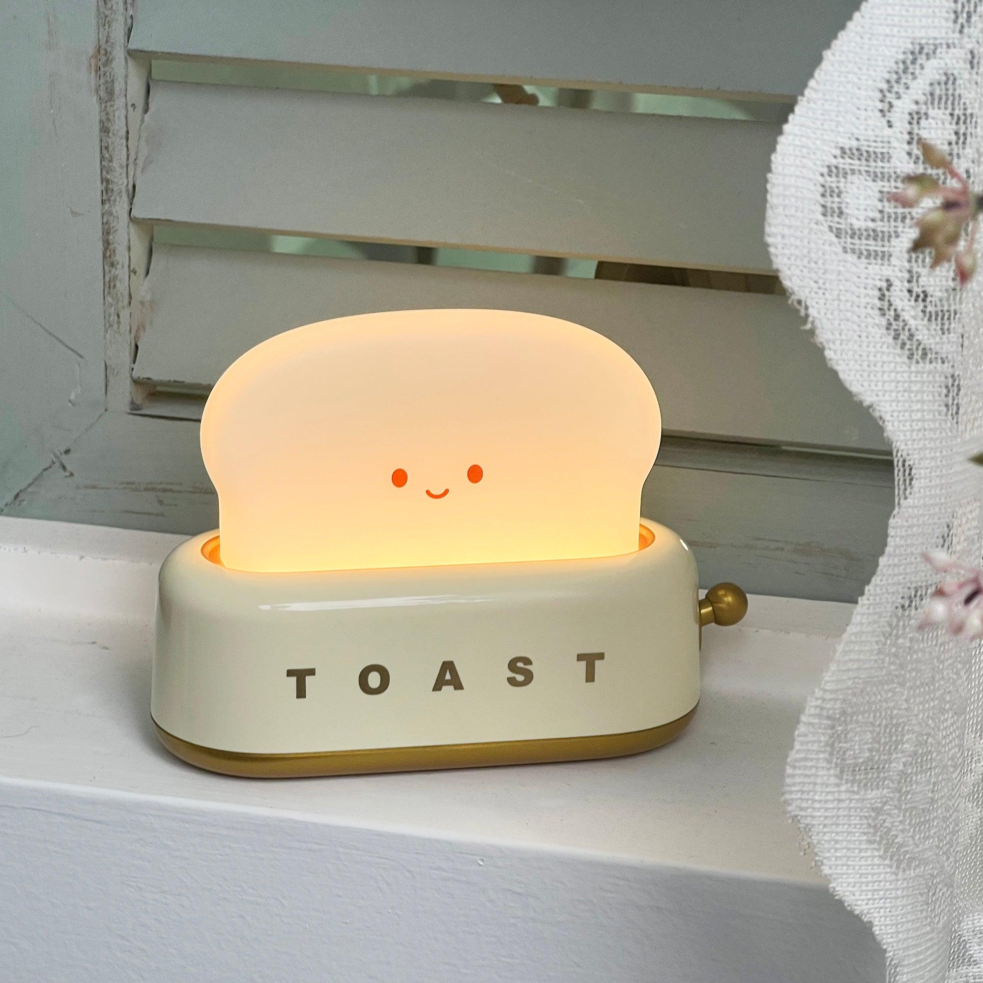 Toy toaster with a smiling face on a white surface