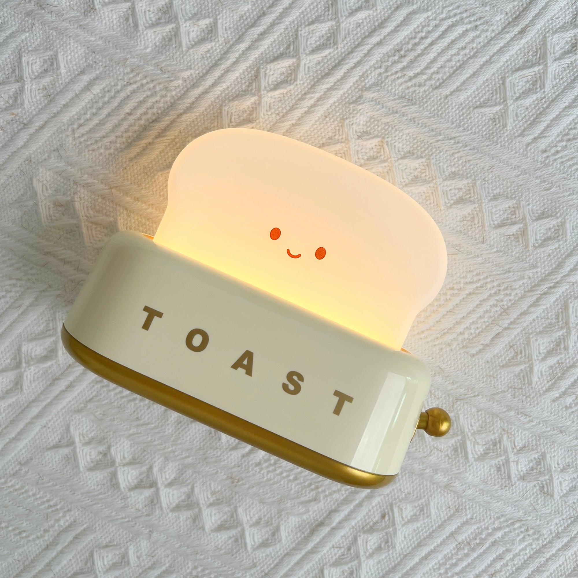 Light-up toaster-shaped night light with a smiling face on a textured white background