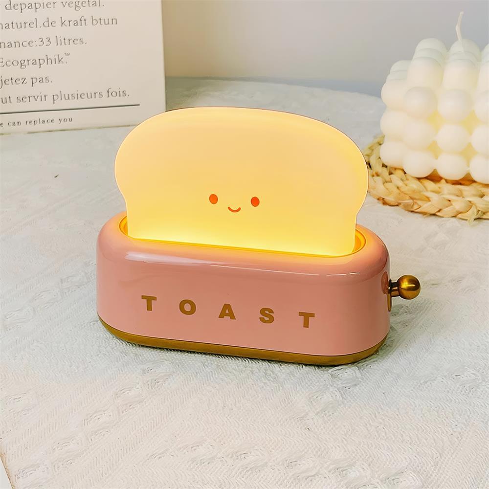 Toy toaster with a smiling face on a light surface