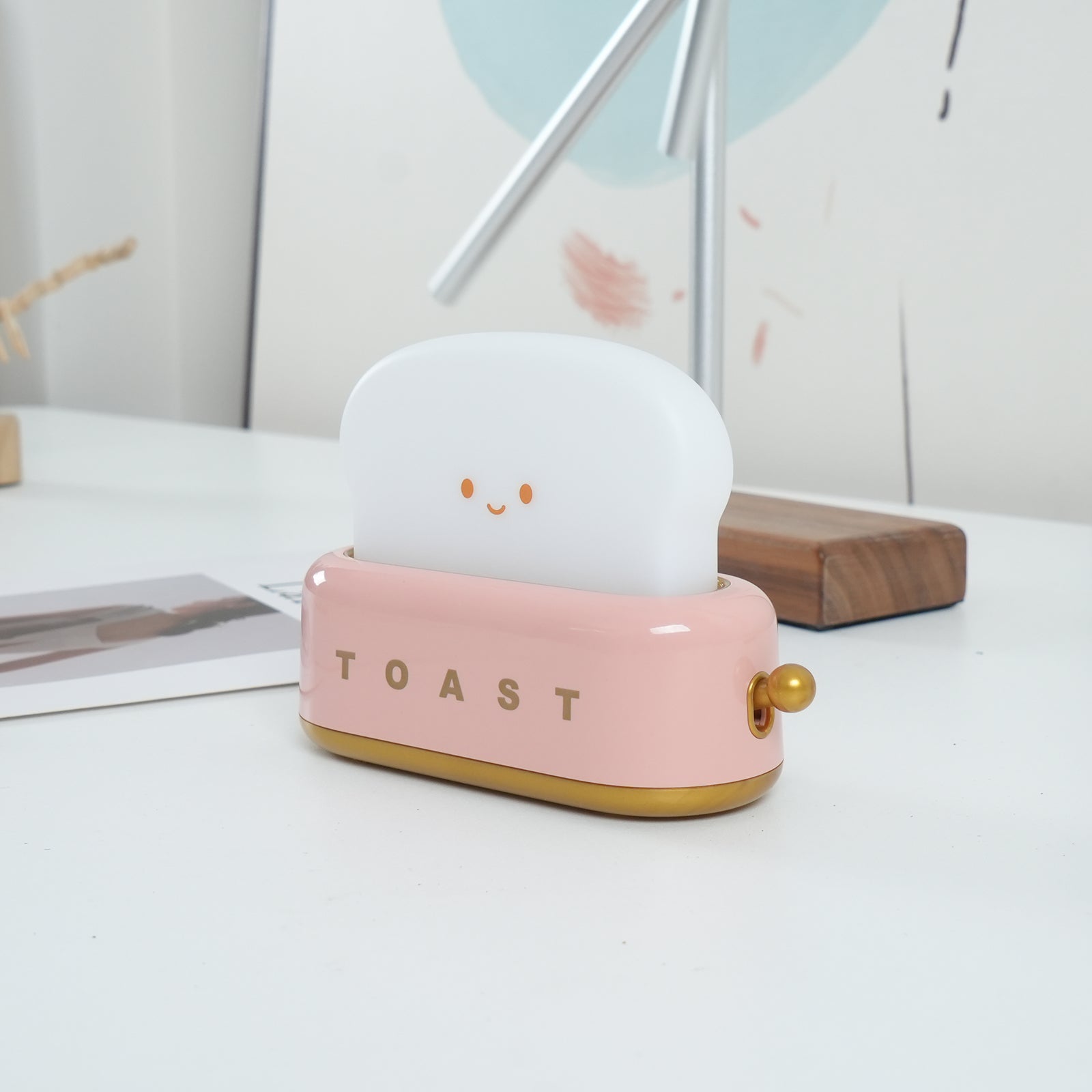 Pink toy toaster with a white cloud-like top on a light surface.