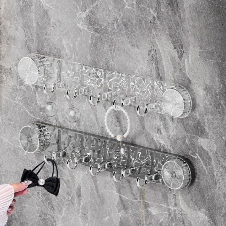 Wall-mounted jewelry organizer with various items on a marble wall.