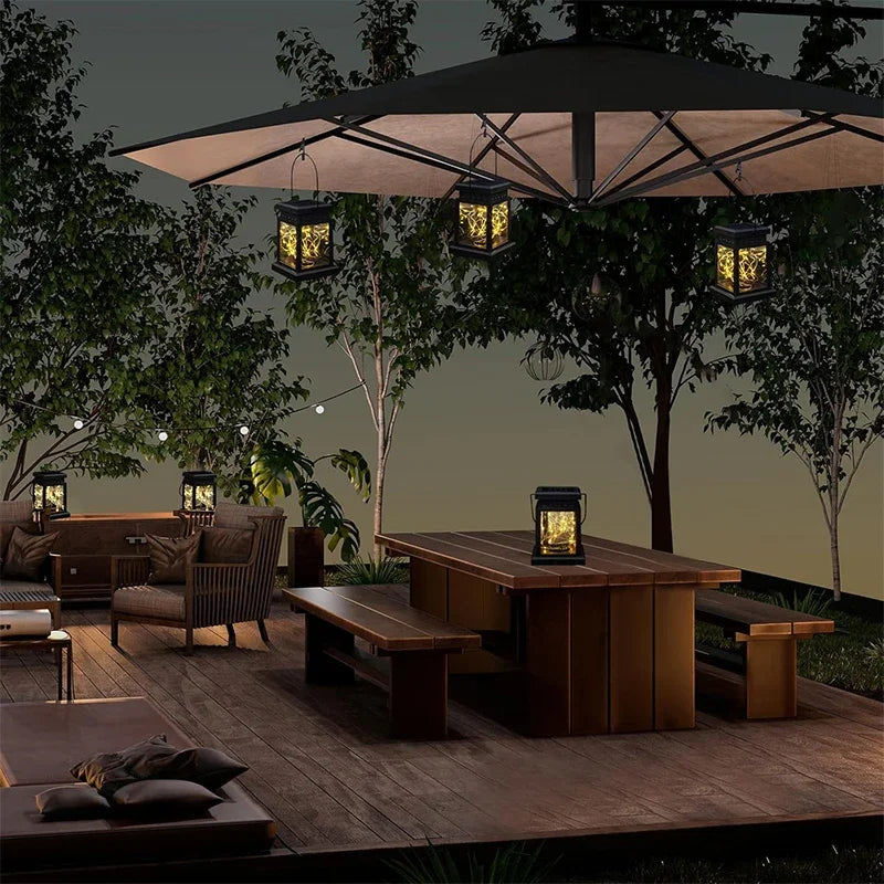 Outdoor patio setting with wooden furniture, large umbrella, and hanging lanterns at night.