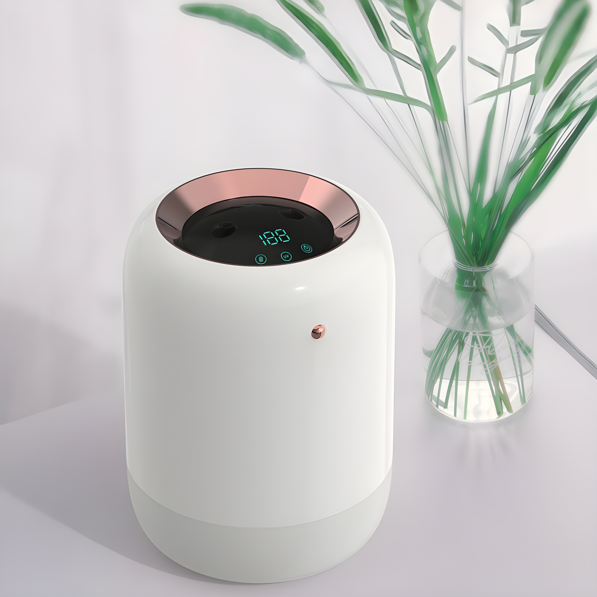 White electronic device with digital display next to a clear vase with green plants on a white background
