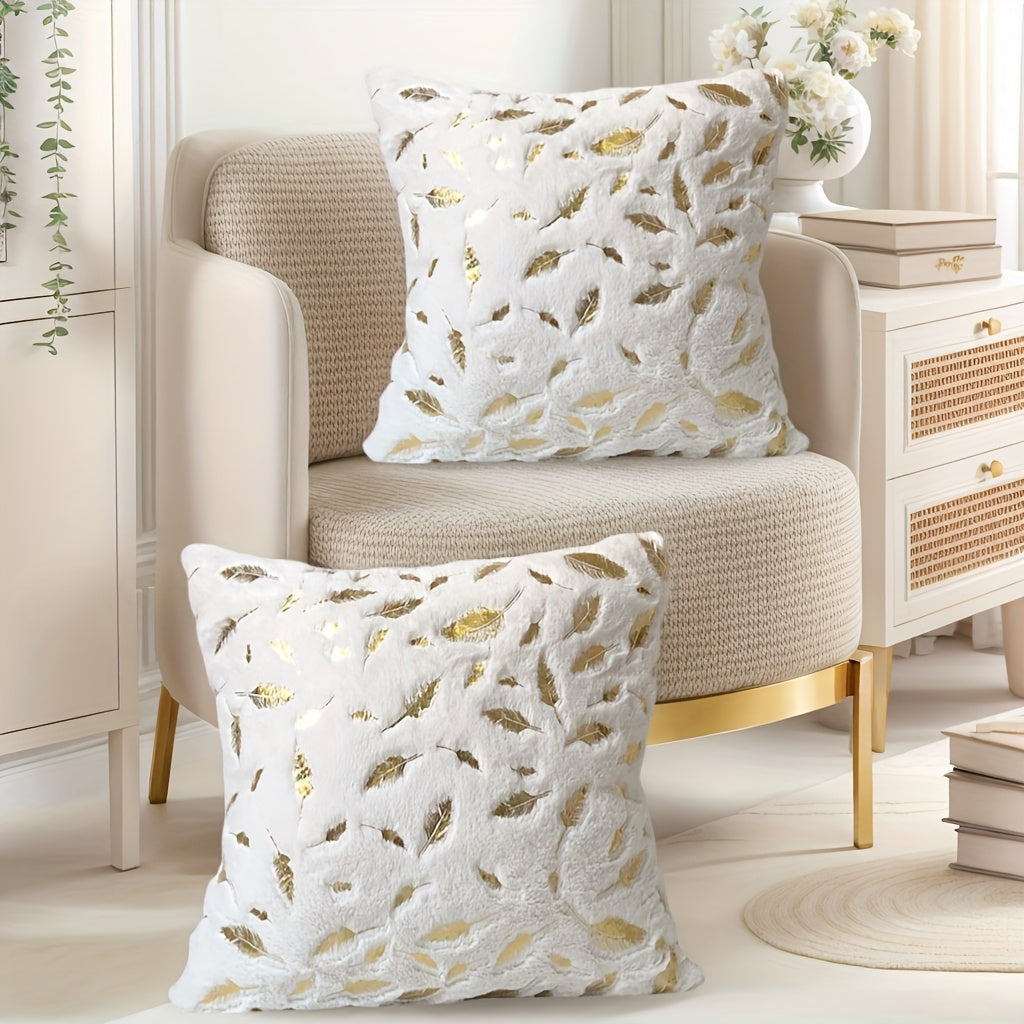 Decorative pillows with gold leaf pattern on a beige armchair in a stylish room.