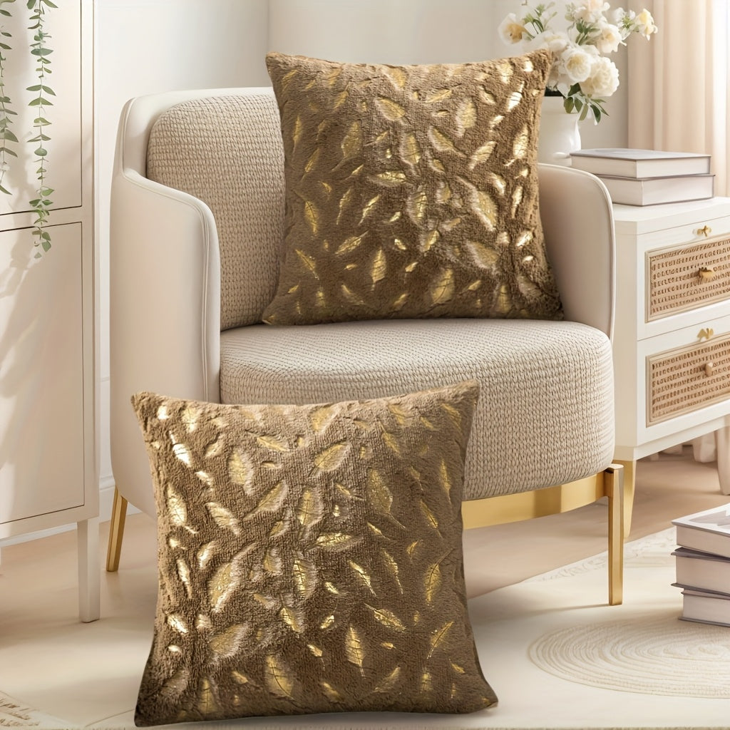Decorative pillows with leaf pattern on a beige armchair in a home setting.