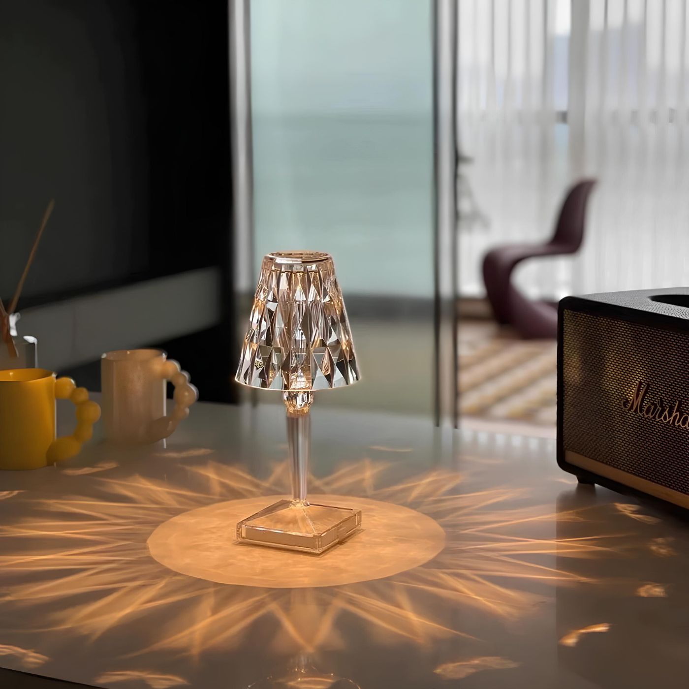 Small table lamp casting a warm glow on a surface with a blurred room background