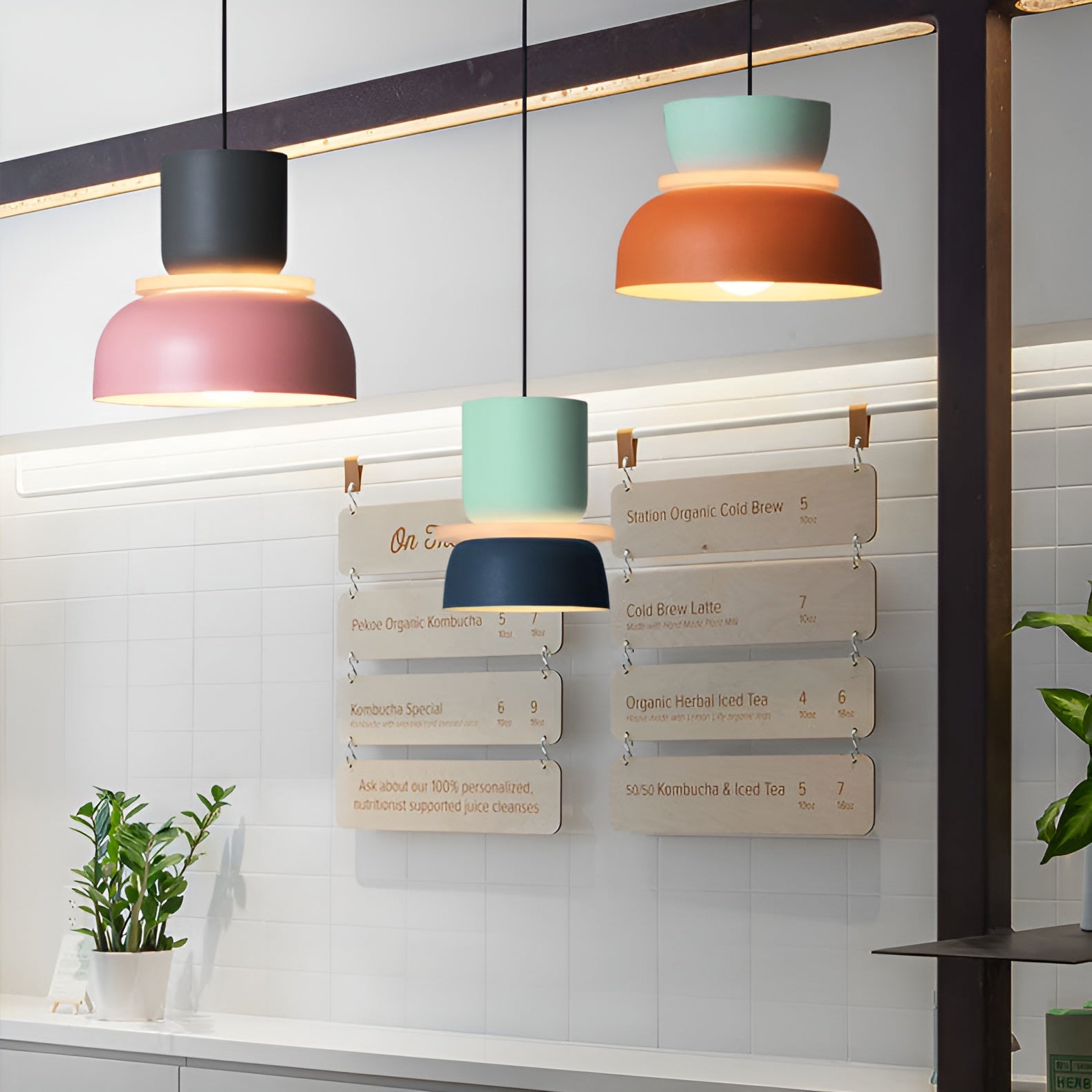 Colorful pendant lights hanging above a counter with menu boards in the background.