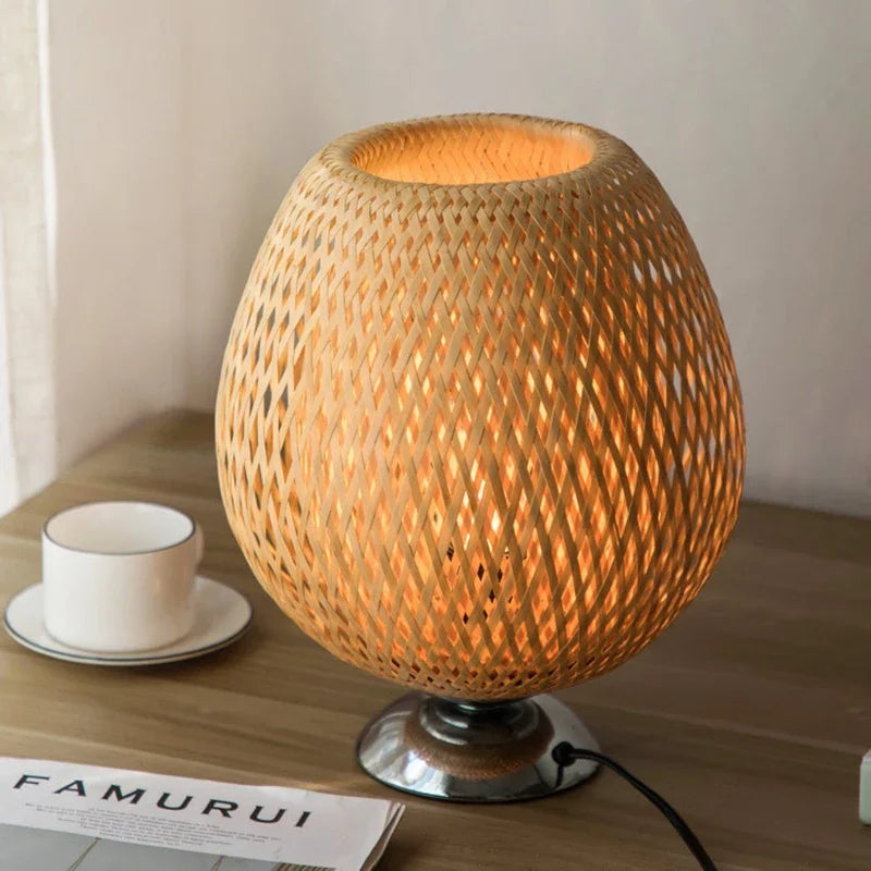 Woven lamp on a wooden surface with a cup and saucer in the background