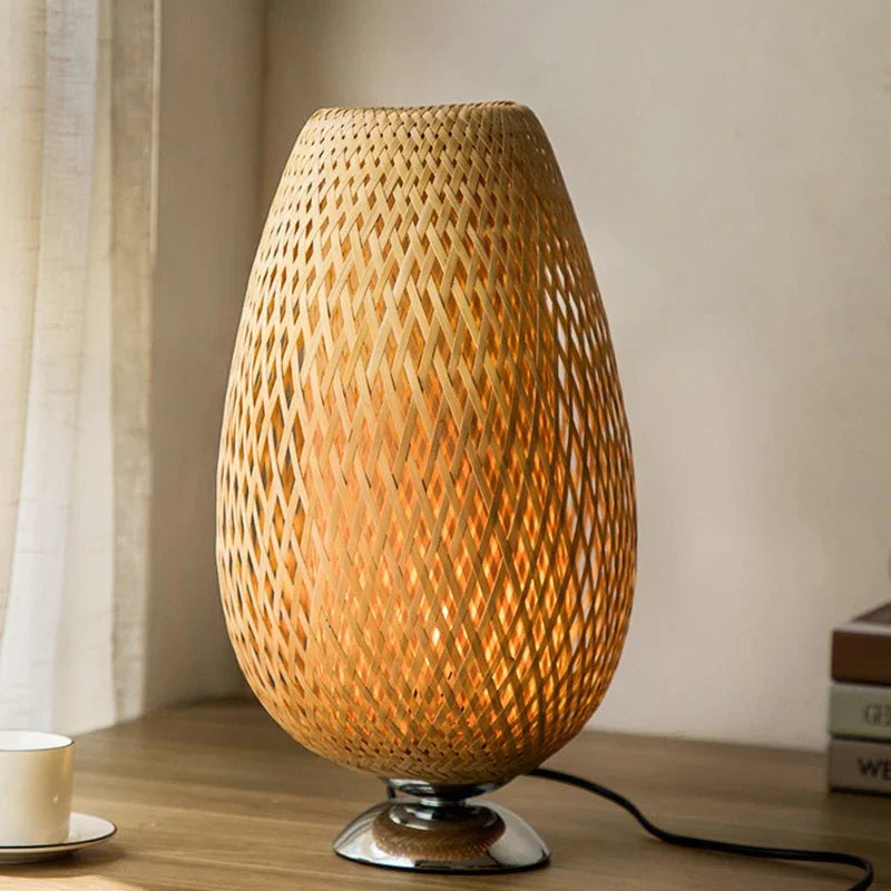 Woven rattan table lamp on a wooden surface with a neutral background