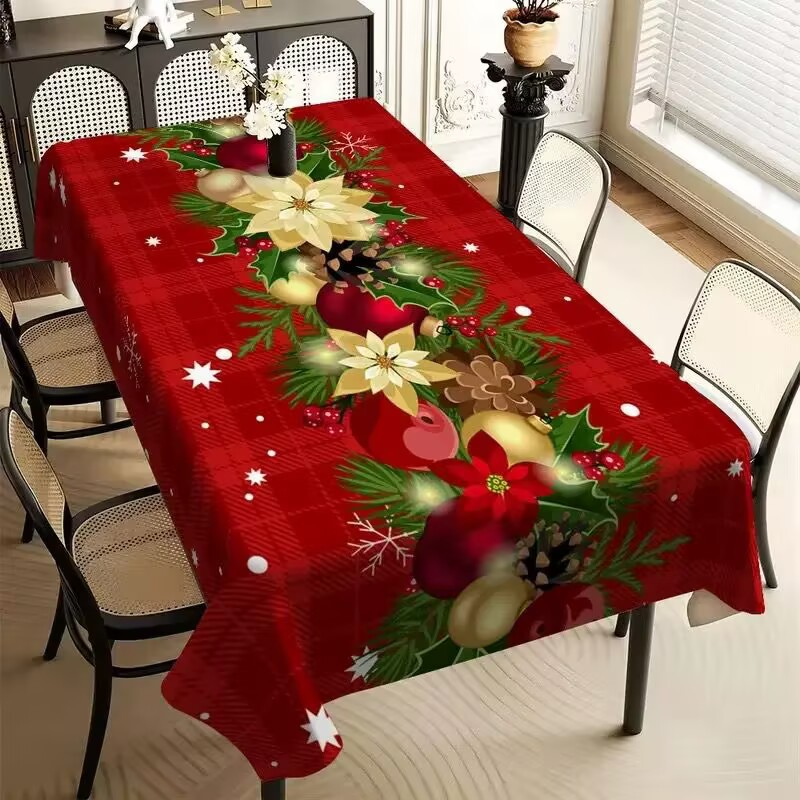 Dining table with a Christmas-themed tablecloth featuring poinsettias and holly.