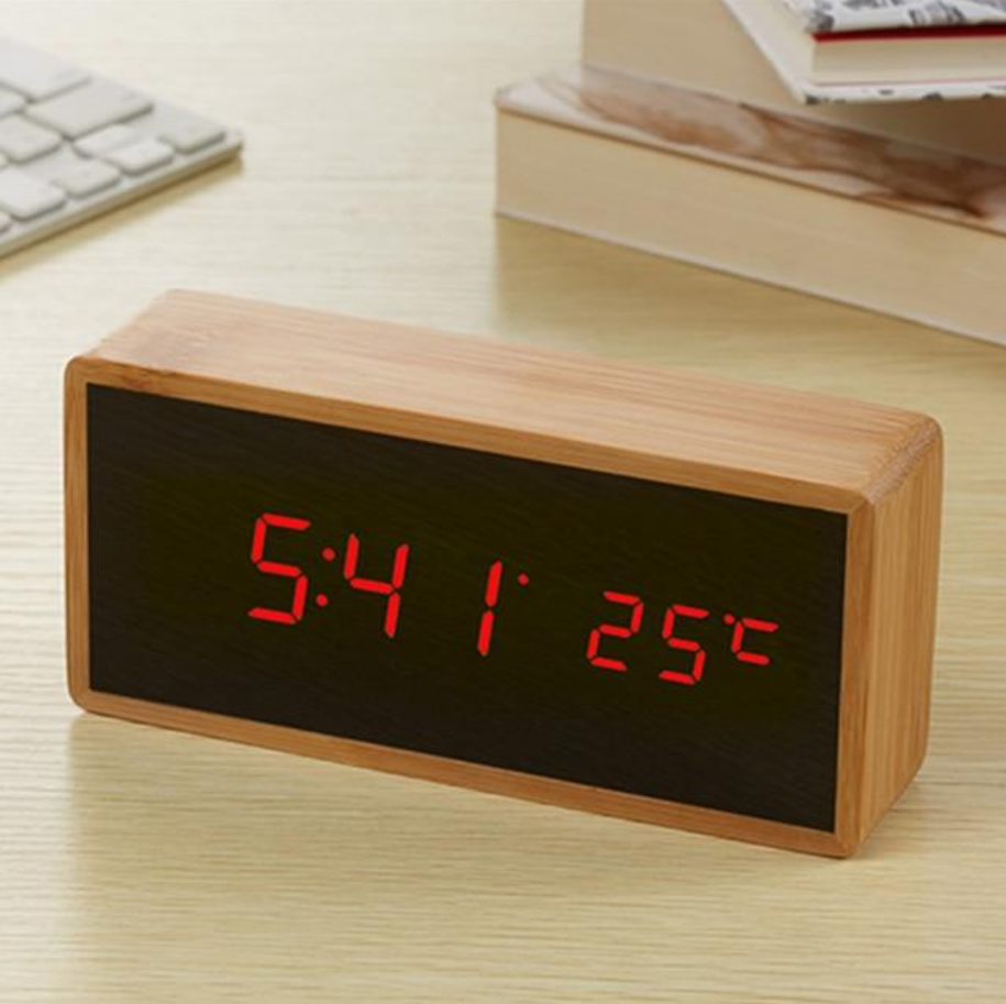 Wooden digital clock with red LED display on a light surface