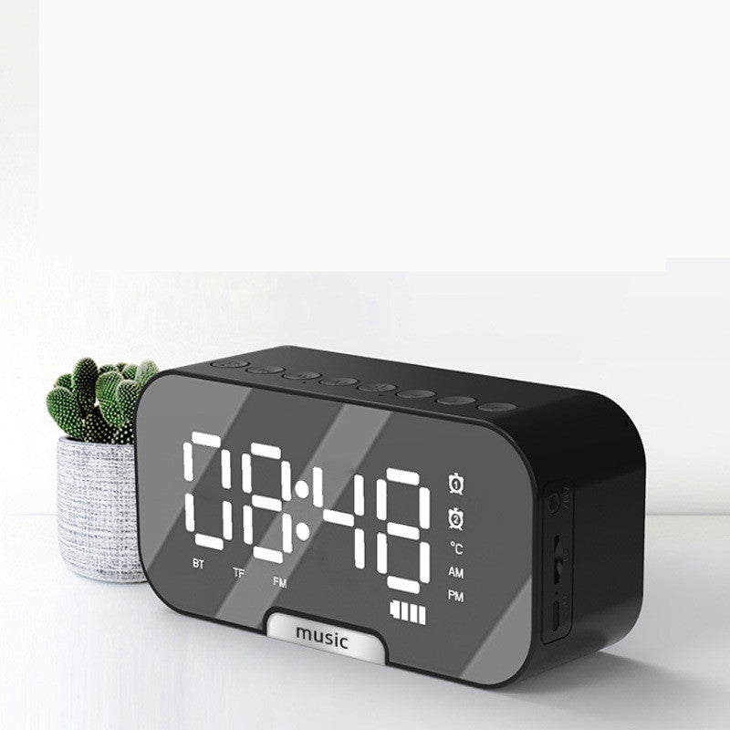 Black digital clock with LED display on a white background