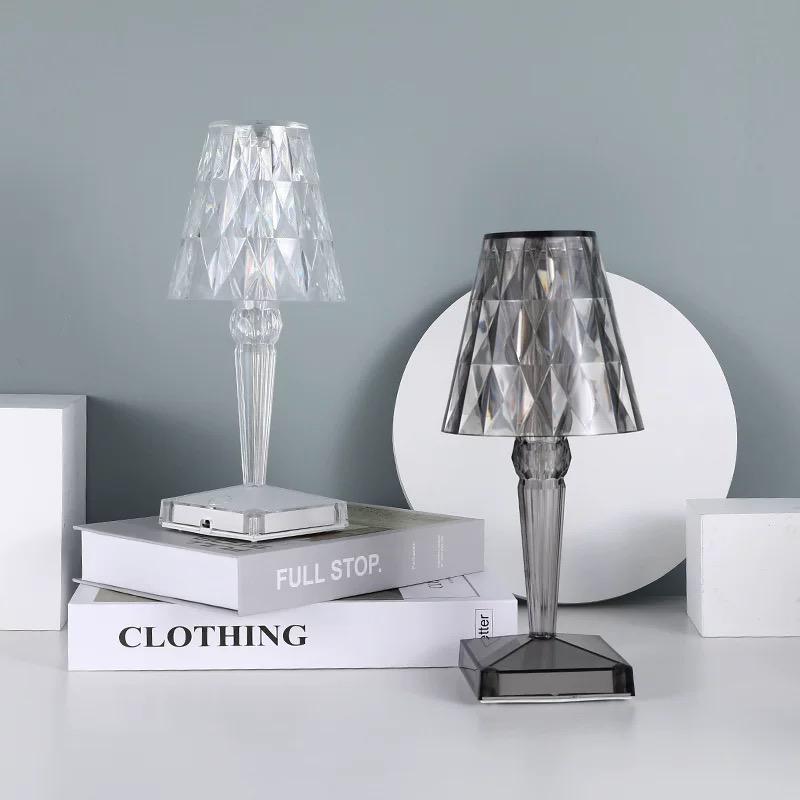 Two table lamps on books with a gray wall background