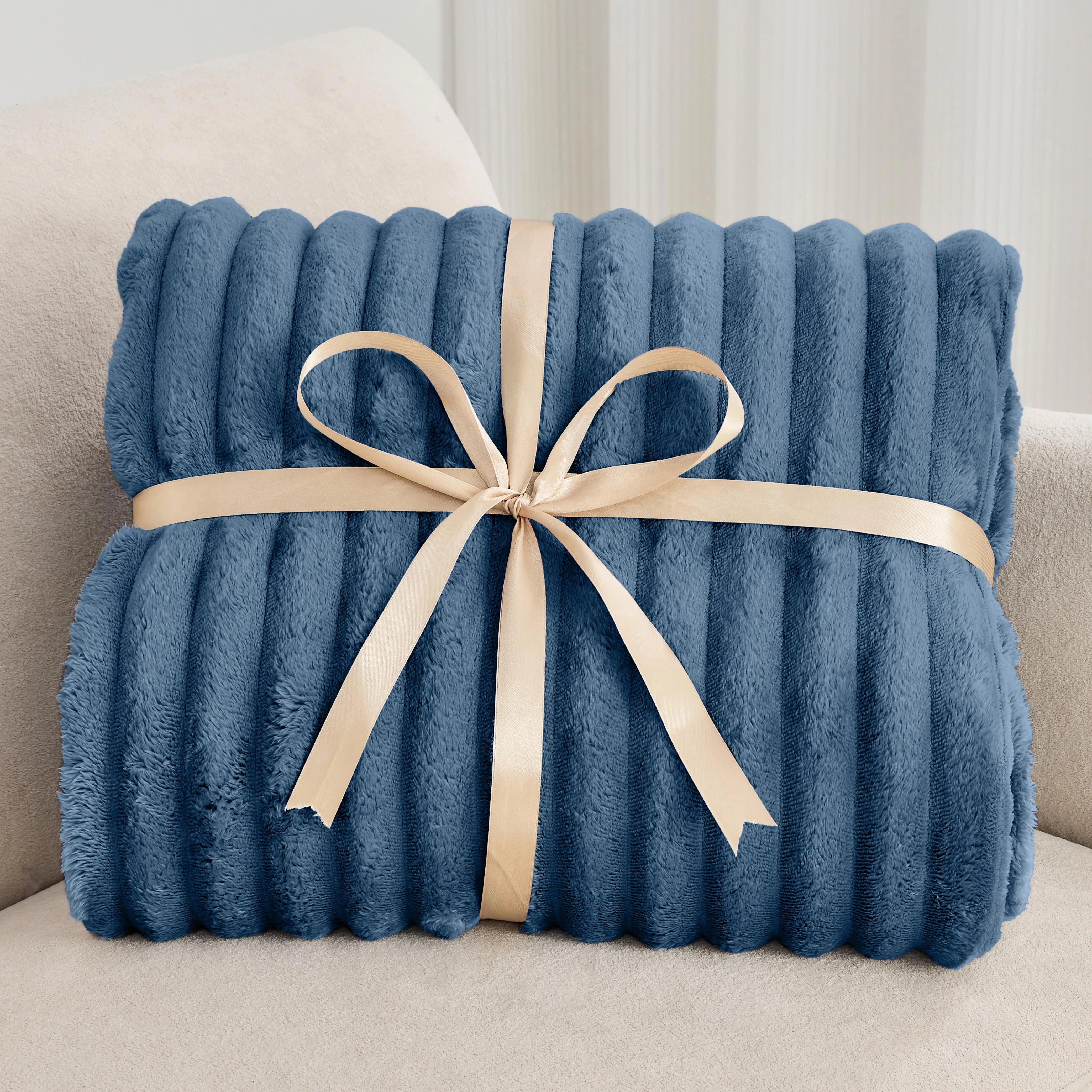 Blue blanket with a beige ribbon on a light-colored couch