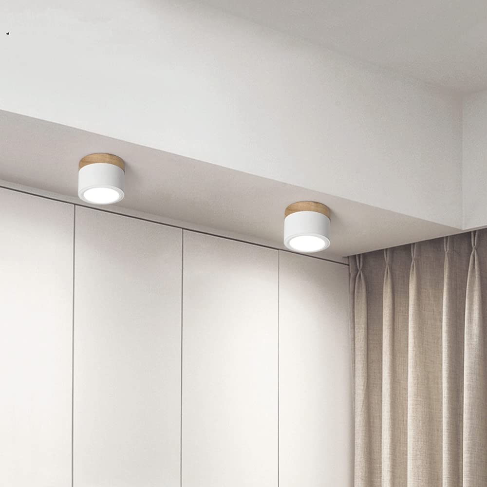 Two ceiling lights on a white wall with a curtain in the background