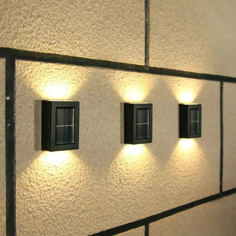 Three outdoor wall lights mounted on a textured wall.